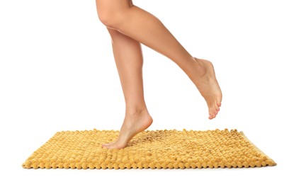 Photo of Woman standing on soft orange bath mat against white background, closeup