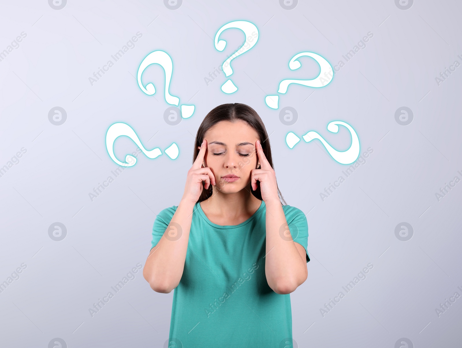 Image of Amnesia concept. Woman surrounded by question marks trying to remember something on light background