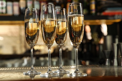 Glasses of champagne on counter in bar