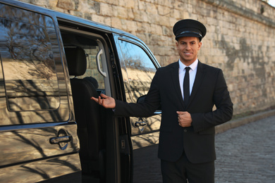 Photo of Professional driver near luxury car outdoors. Chauffeur service