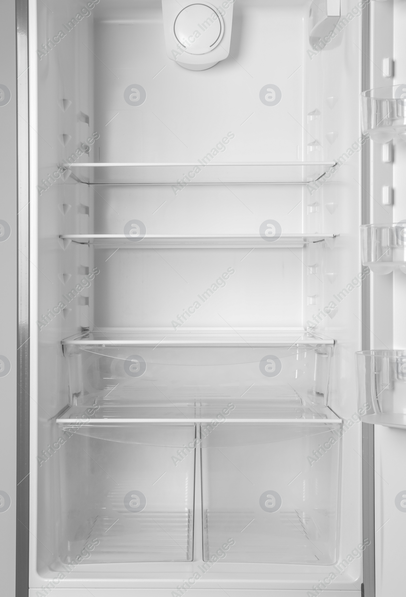 Photo of Modern open refrigerator with empty shelves, closeup