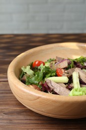 Photo of Delicious salad with beef tongue and vegetables on wooden table, closeup. Space for text