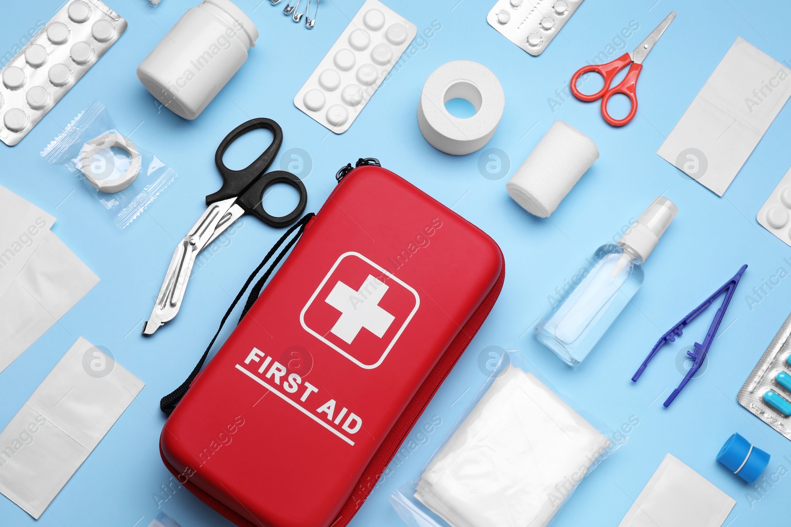 Photo of Flat lay composition with first aid kit on light blue background