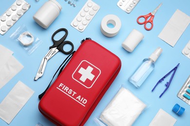 Photo of Flat lay composition with first aid kit on light blue background