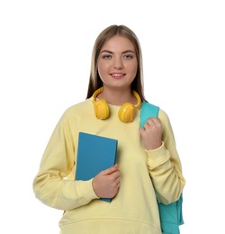 Teenage student with headphones, backpack and book on white background