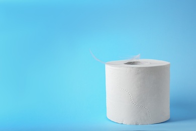 Photo of Roll of toilet paper with feather on color background. Space for text