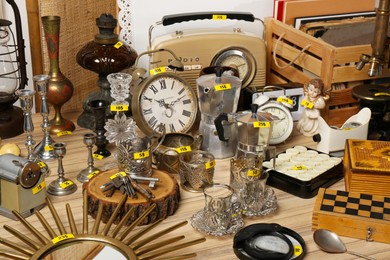Photo of Many different items on wooden table. Garage sale