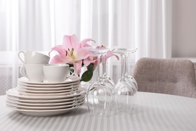 Photo of Set of clean dishware and wine glasses on table indoors