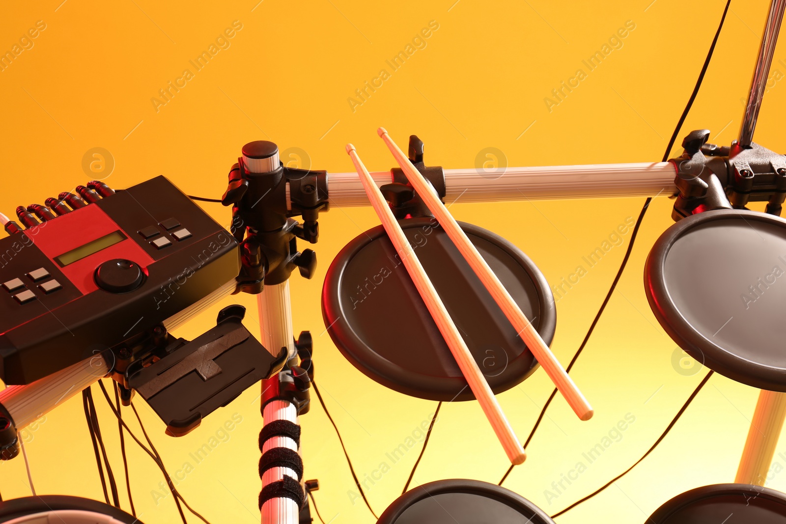 Photo of Modern electronic drum kit on yellow background. Musical instrument