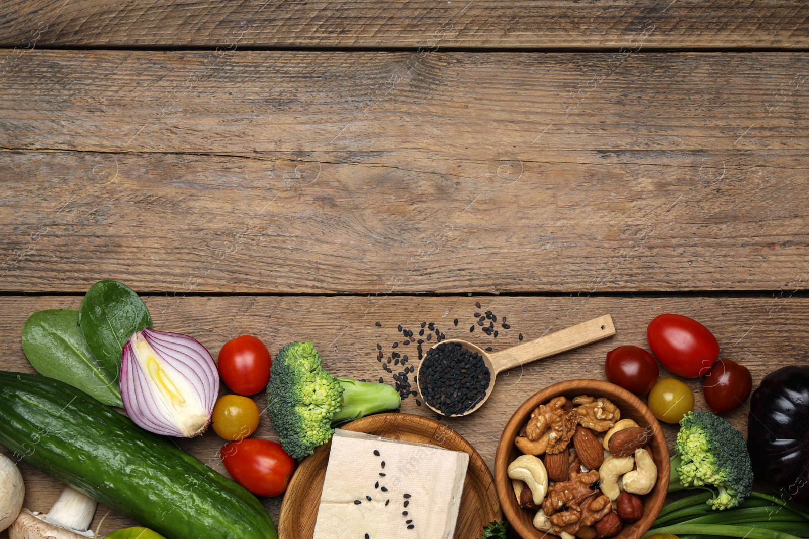 Photo of Different vegetables on wooden table, flat lay and space for text. Vegan diet