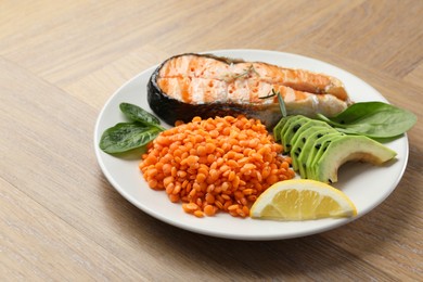 Photo of Plate with healthy food high in vegetable fats on wooden table, closeup. Space for text