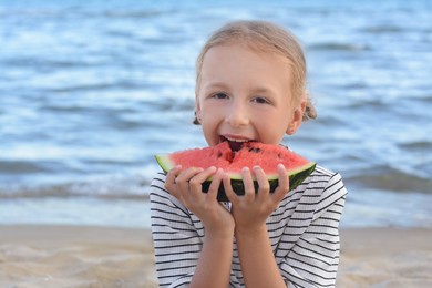 Photo of Cute little girl eating fresh juicy watermelon on beach