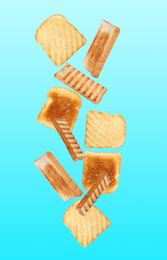 Tasty toasts falling on color background 