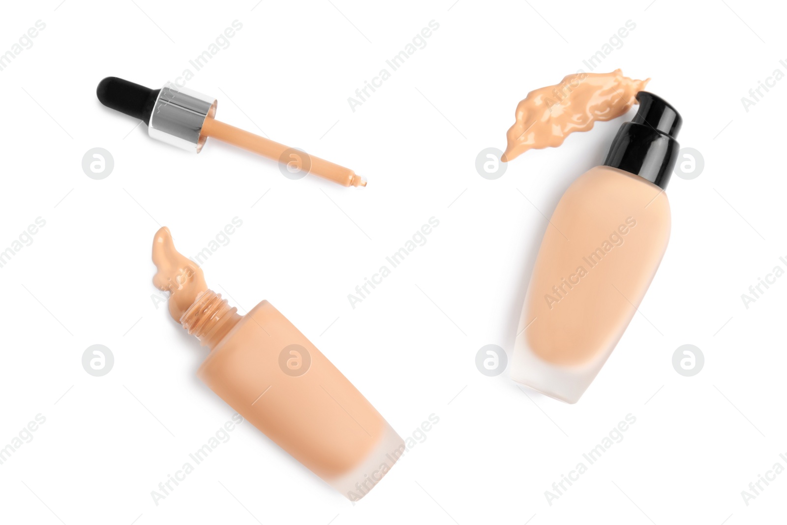 Photo of Bottles of liquid foundation and dropper on white background, top view