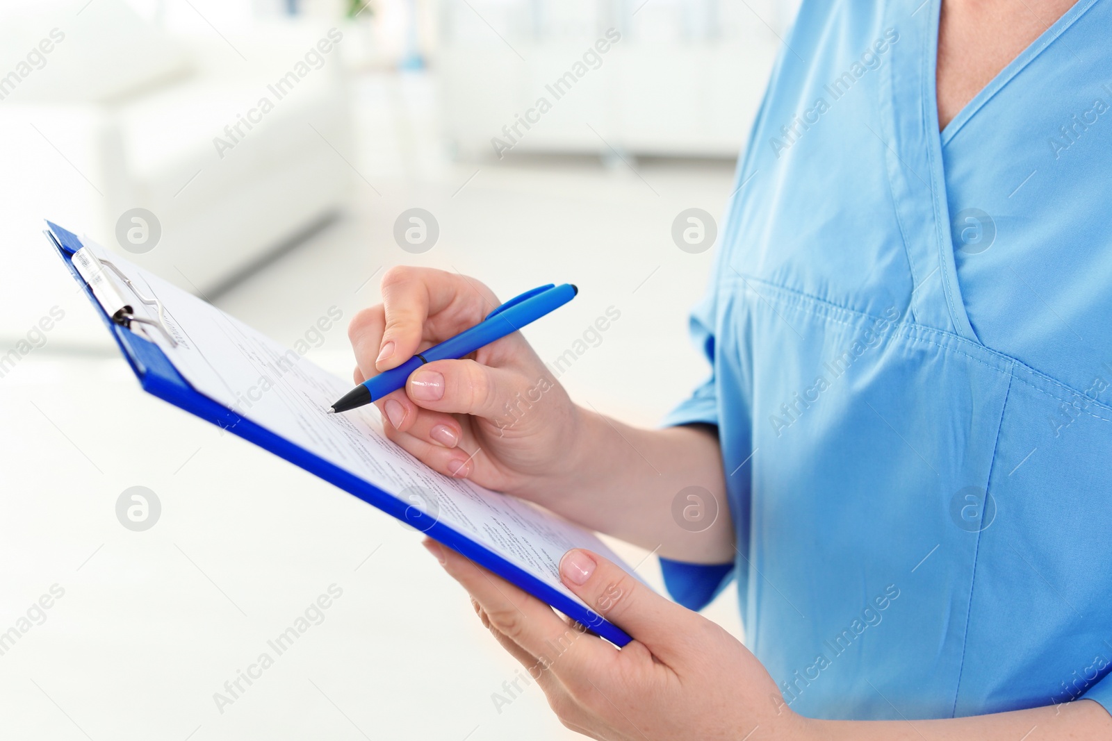 Photo of Female medical assistant with clipboard in clinic, closeup. Health care service