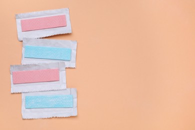 Photo of Unwrapped sticks of chewing gum on coral background, flat lay. Space for text