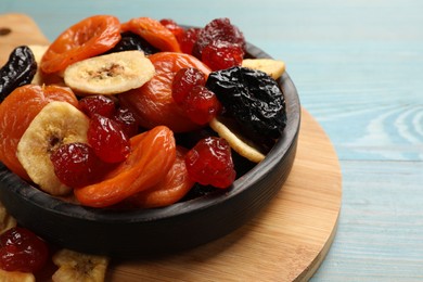 Photo of Mix of delicious dried fruits on light blue wooden table, closeup