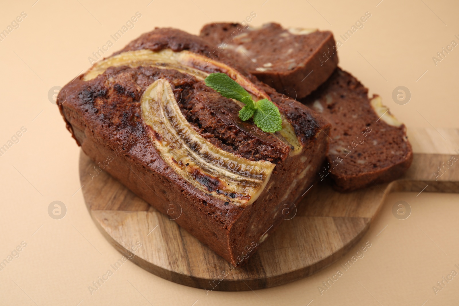 Photo of Delicious banana bread with mint on beige background, closeup