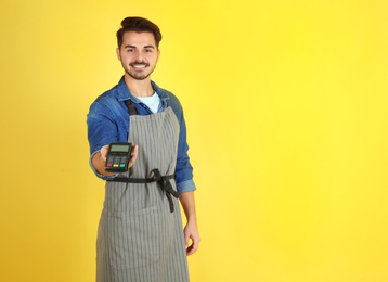 Photo of Waiter with payment terminal on color background. Space for text