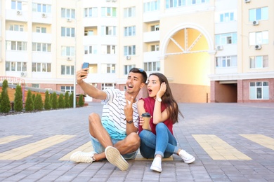 Young couple taking selfie on city street