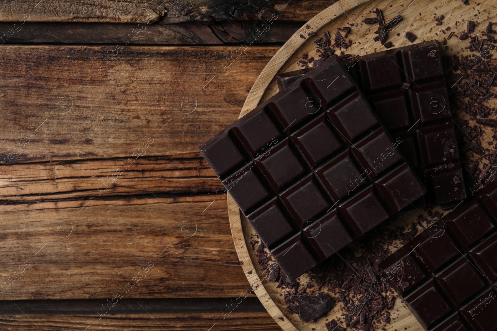 Photo of Tasty dark chocolate on wooden table, top view. Space for text