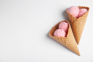 Delicious ice creams in wafer cones on white background, top view