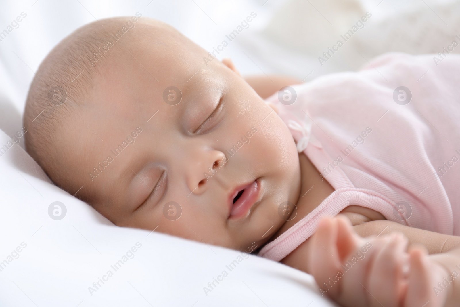 Photo of Cute little baby sleeping on bed, closeup