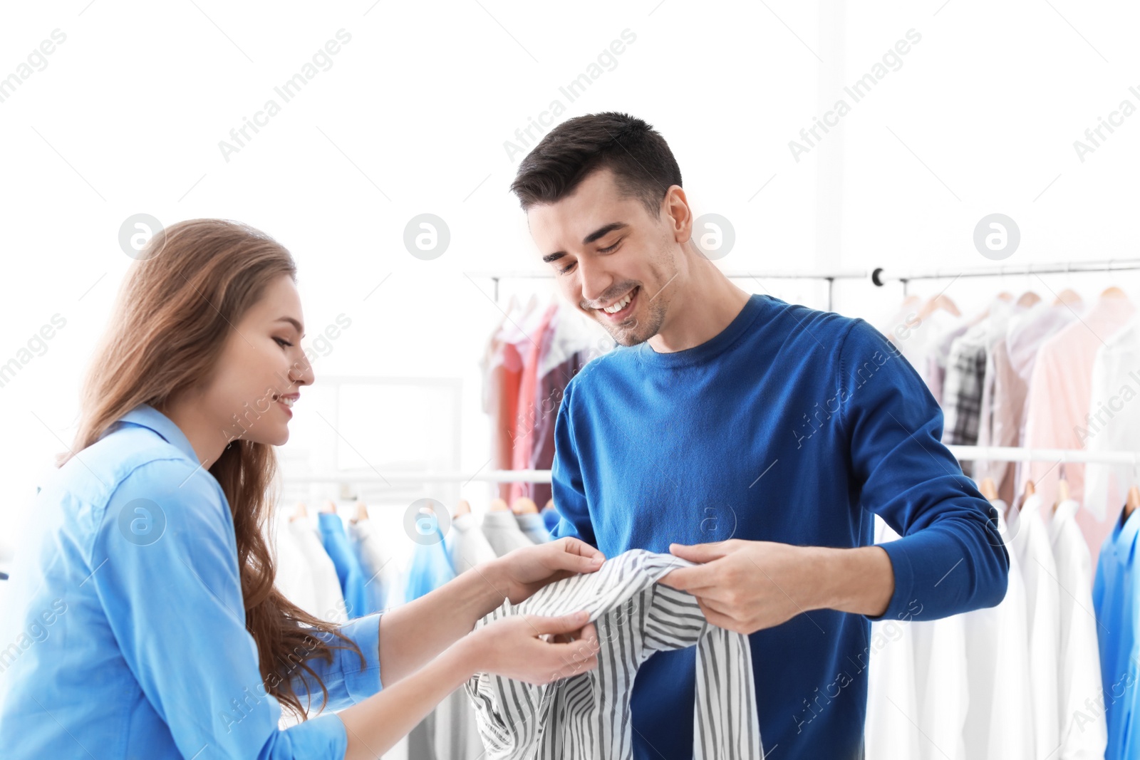 Photo of Young woman giving shirt to dry-cleaner's worker