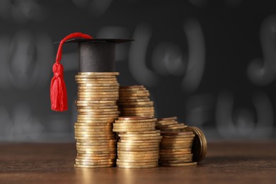 Photo of Scholarship concept. Coins and graduation cap on wooden table