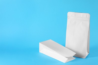 Photo of Two paper bags on light blue background, space for text
