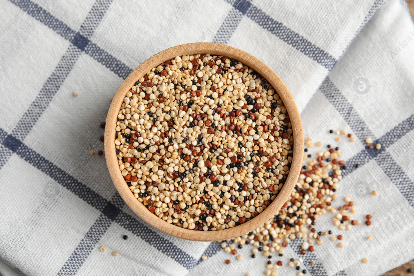 Photo of Bowl with mixed quinoa seeds on cloth, top view