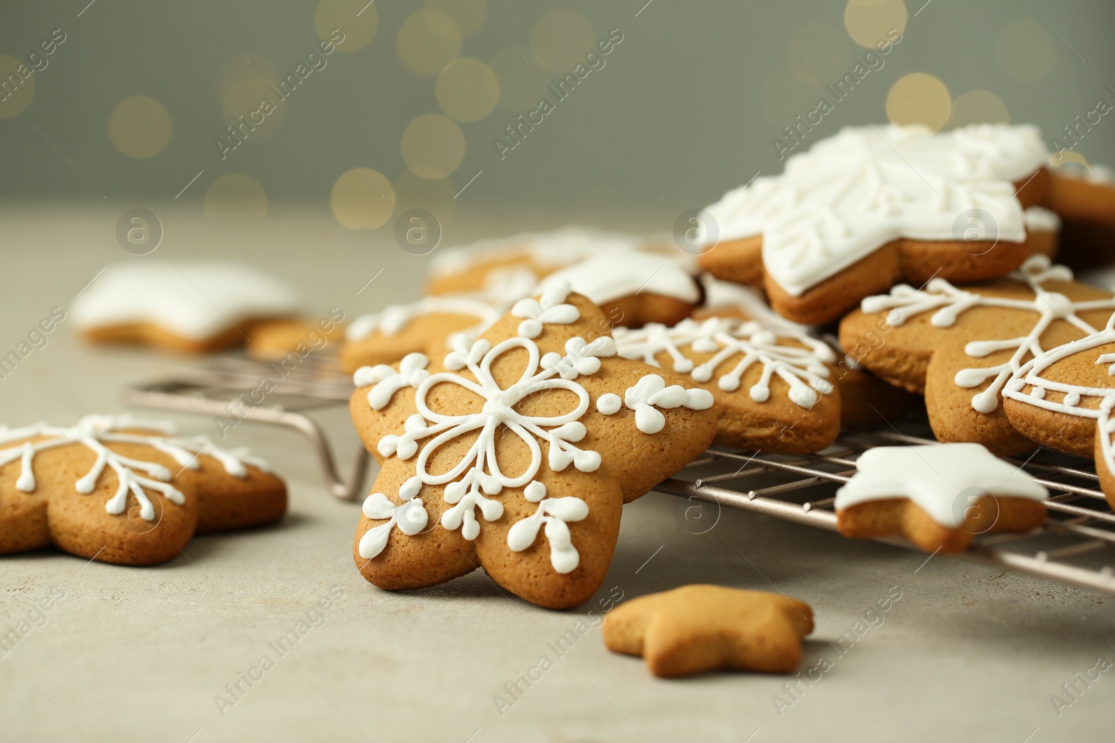 Photo of Tasty Christmas cookies with icing on table against blurred lights, closeup