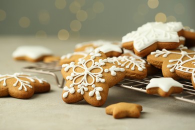 Tasty Christmas cookies with icing on table against blurred lights, closeup