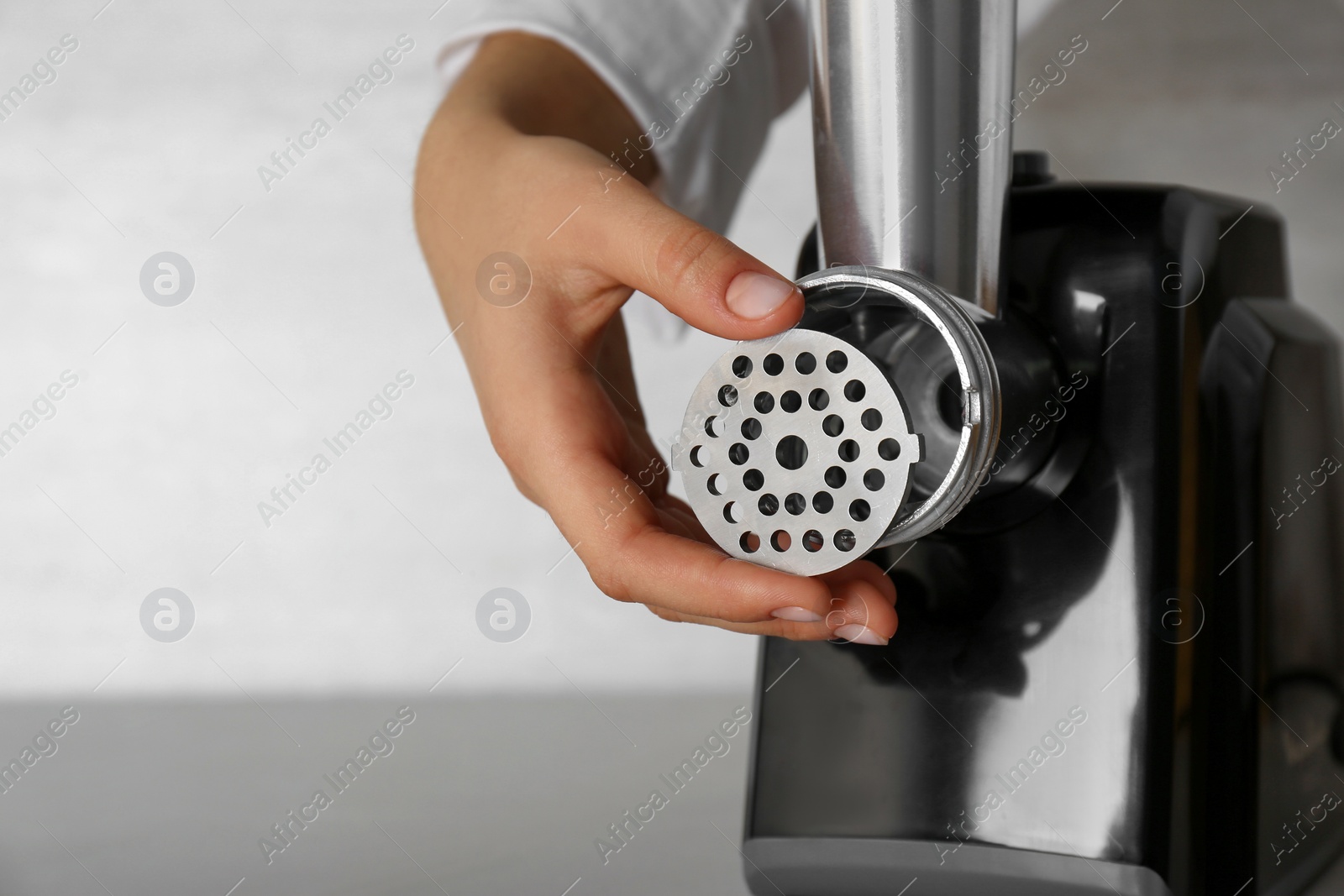 Photo of Woman assembling electric meat grinder, closeup. Space for text