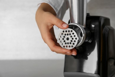 Woman assembling electric meat grinder, closeup. Space for text