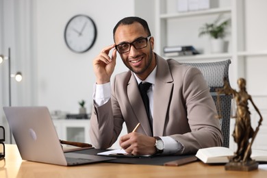 Photo of Portrait of smiling lawyer at table in office