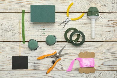 Photo of Florist equipment on wooden background, top view