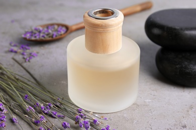 Photo of Bottle with natural herbal oil and lavender flowers on color background