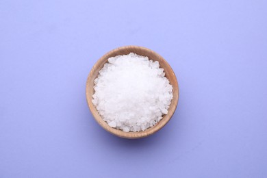 Photo of Bowl of sea salt on violet background, top view