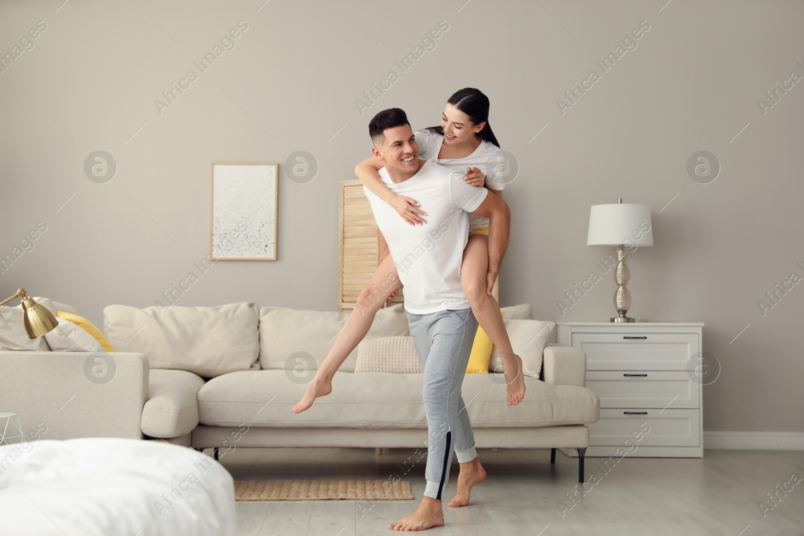 Photo of Happy couple in pyjamas having fun at home