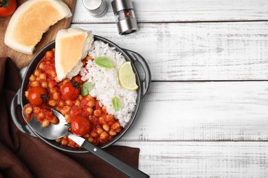 Photo of Delicious chickpea curry with rice served on white wooden table, flat lay. Space for text