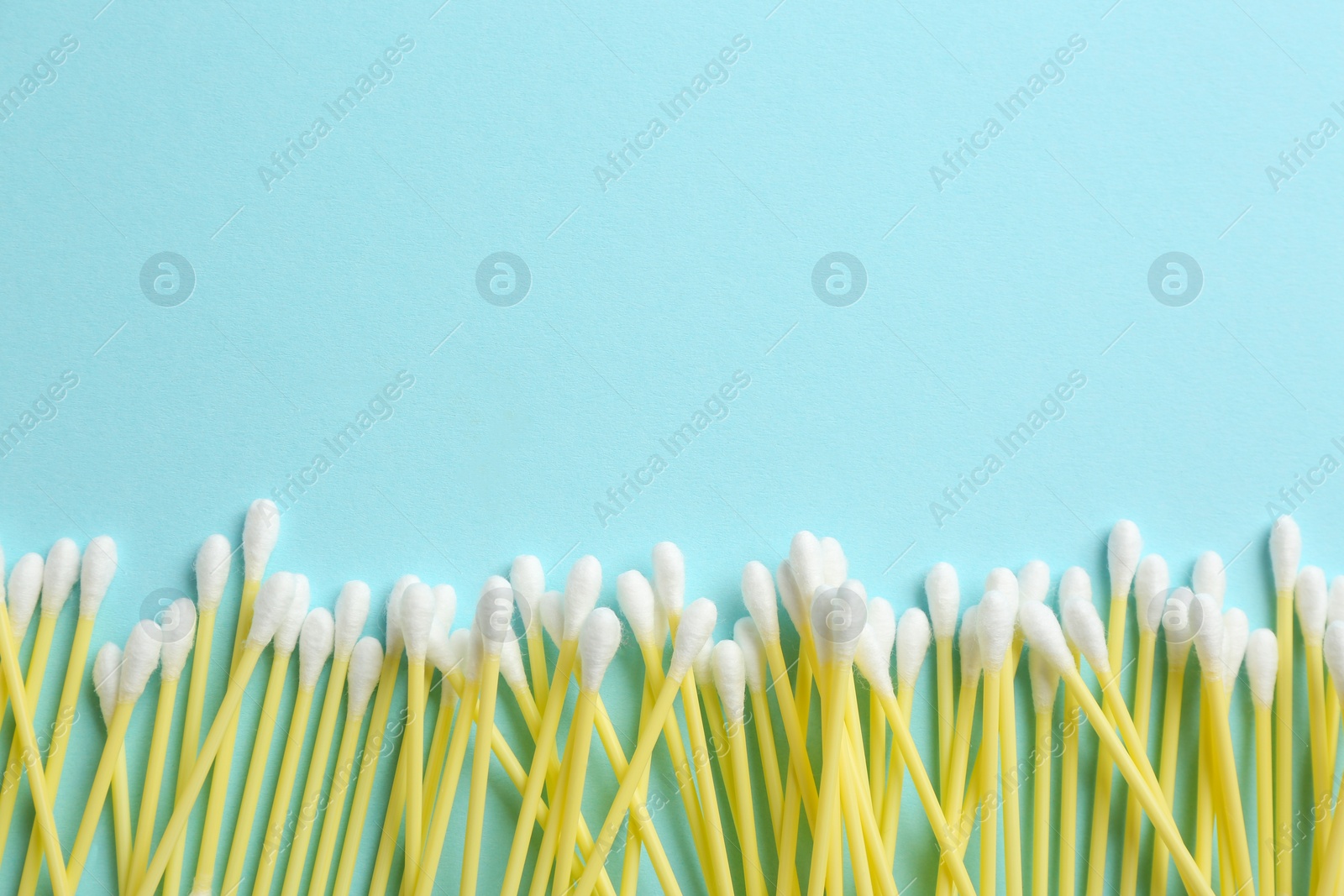 Photo of Flat lay composition with cotton swabs and space for text on color background