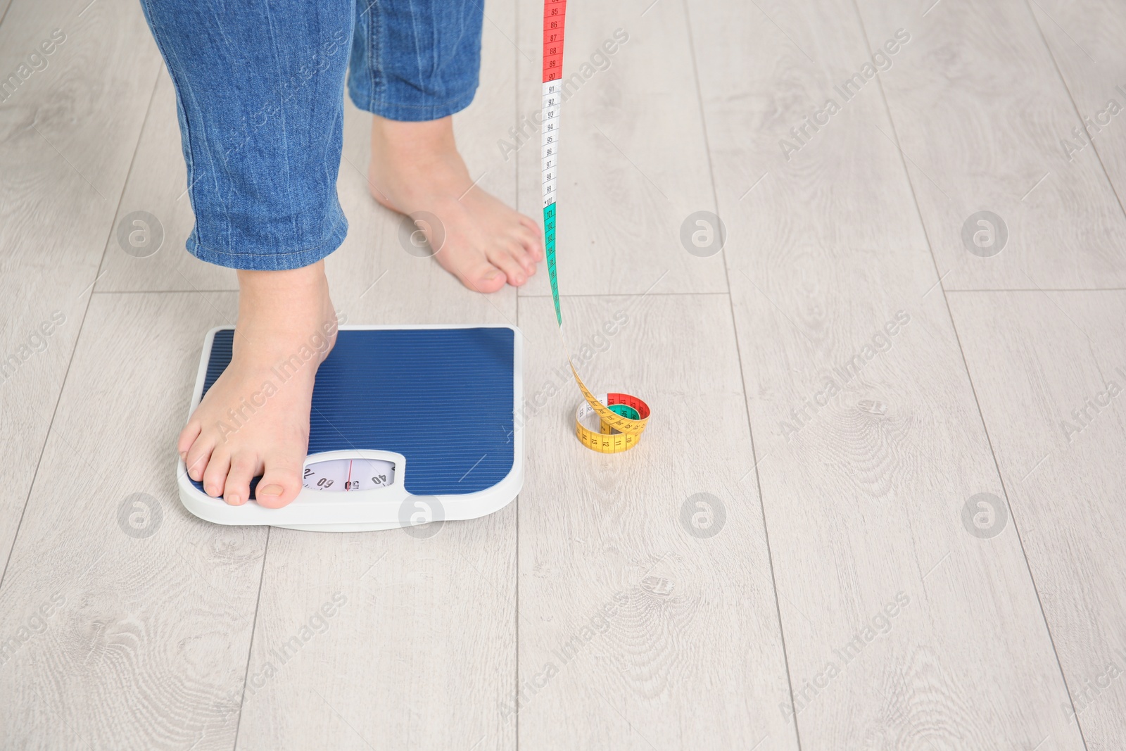 Photo of Overweight woman using scales indoors