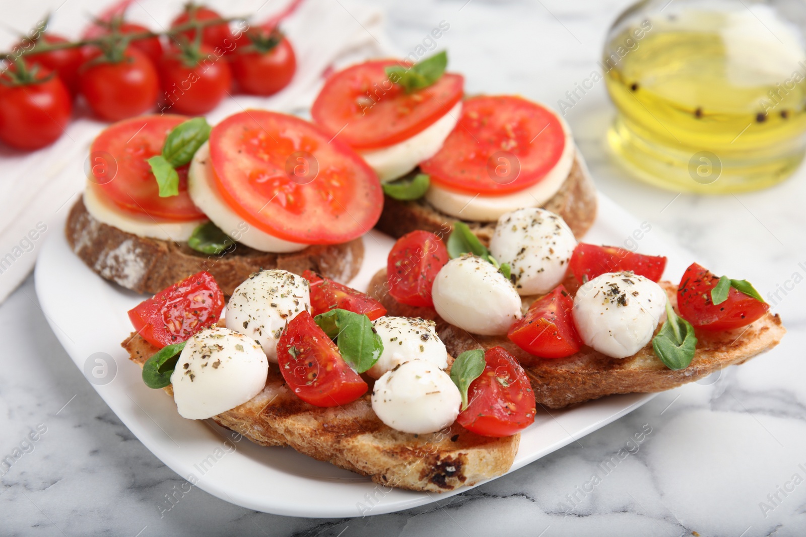 Photo of Delicious sandwiches with mozzarella, fresh tomatoes and basil on white marble table