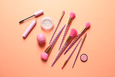 Photo of Flat lay composition with makeup brushes on orange background