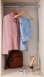 Photo of Collection of accessories and stylish clothes in wardrobe closet