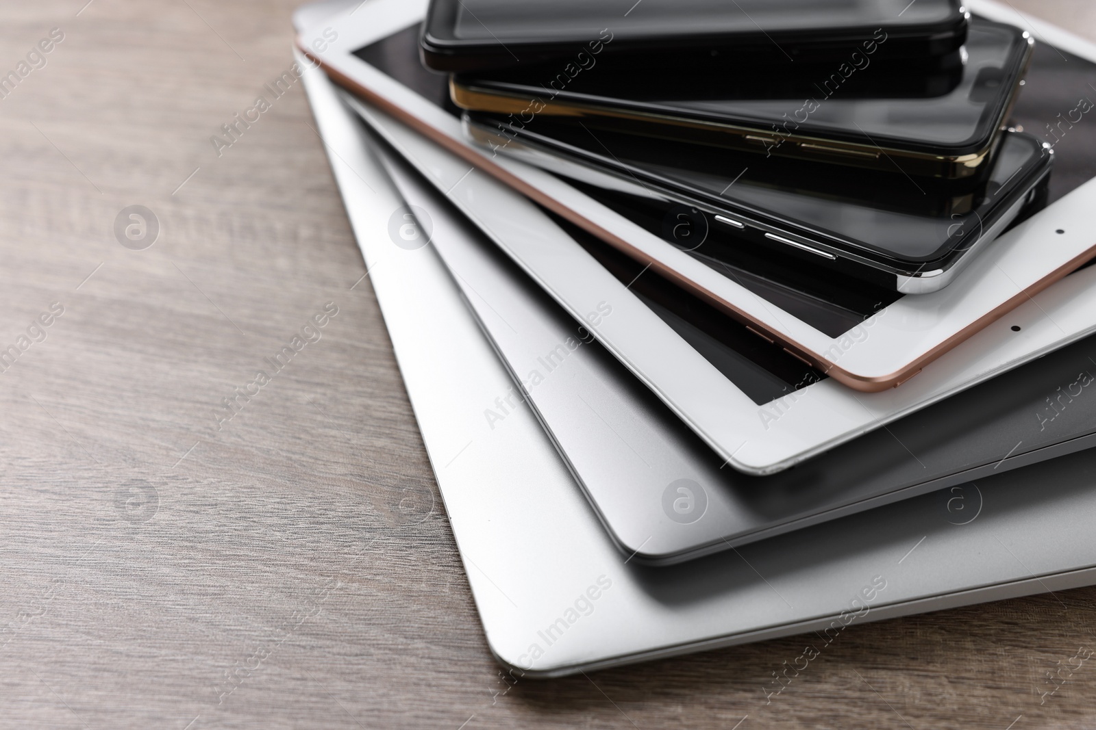 Photo of Many different modern gadgets on wooden table, closeup