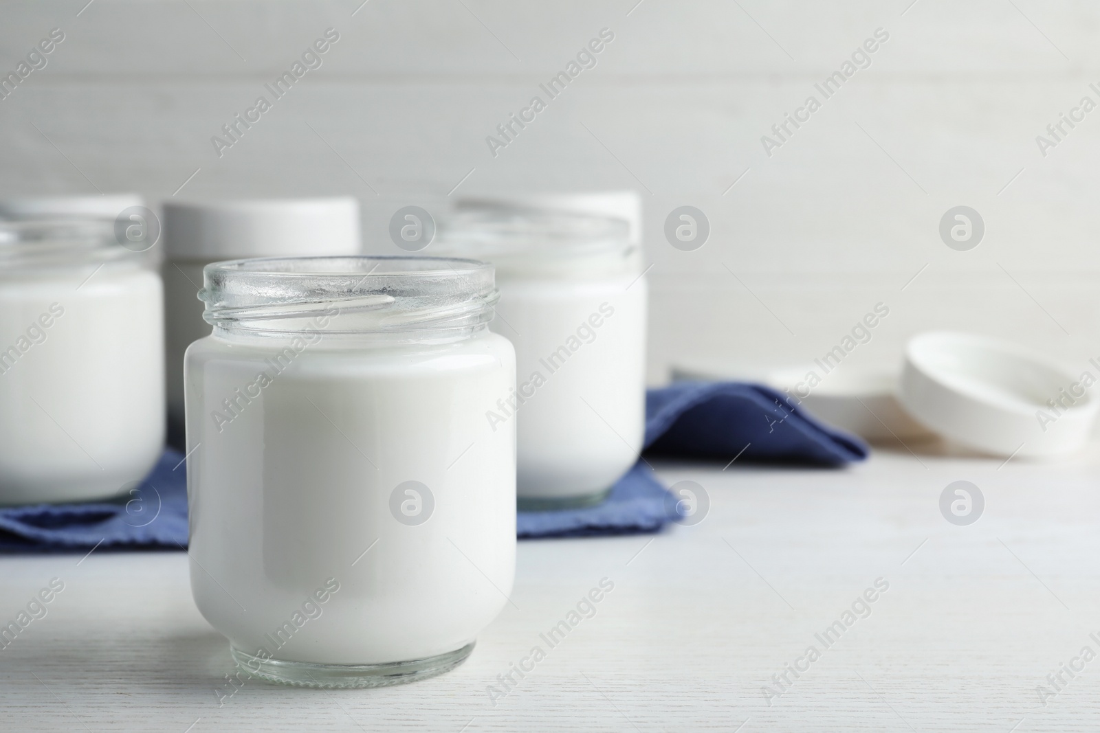 Photo of Tasty yogurt on white wooden table. Space for text