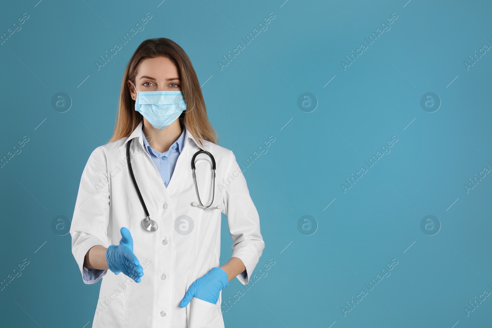 Photo of Doctor in protective mask and gloves offering handshake on light blue background. Space for text
