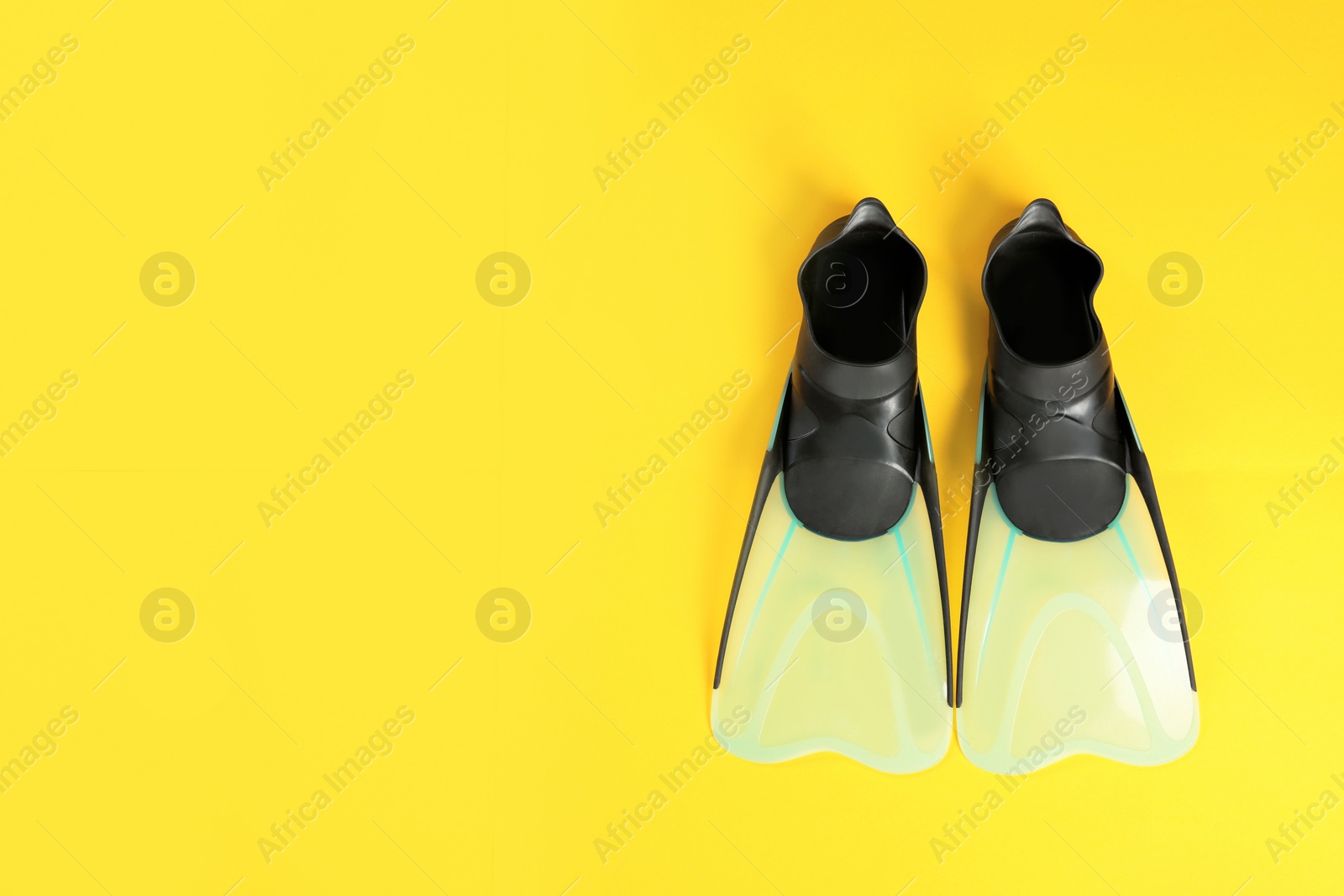 Photo of Swimming flippers on color background, top view. Space for text